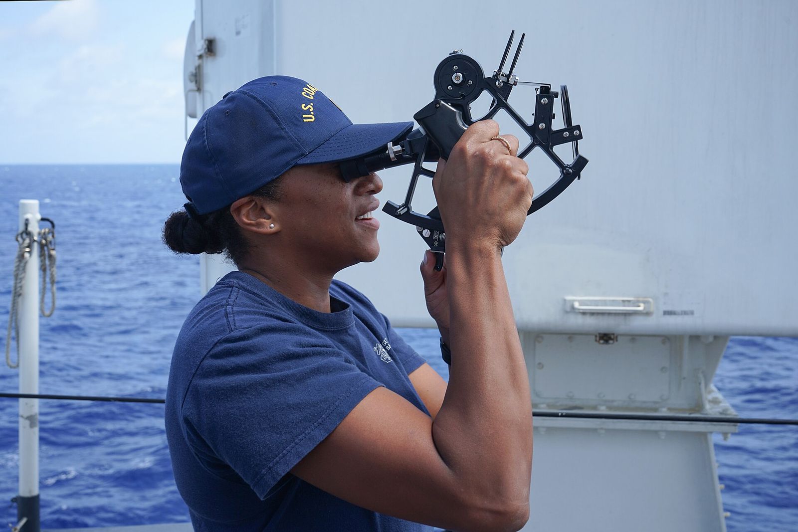 A Coast Guard sailor taking a sight with a sextant