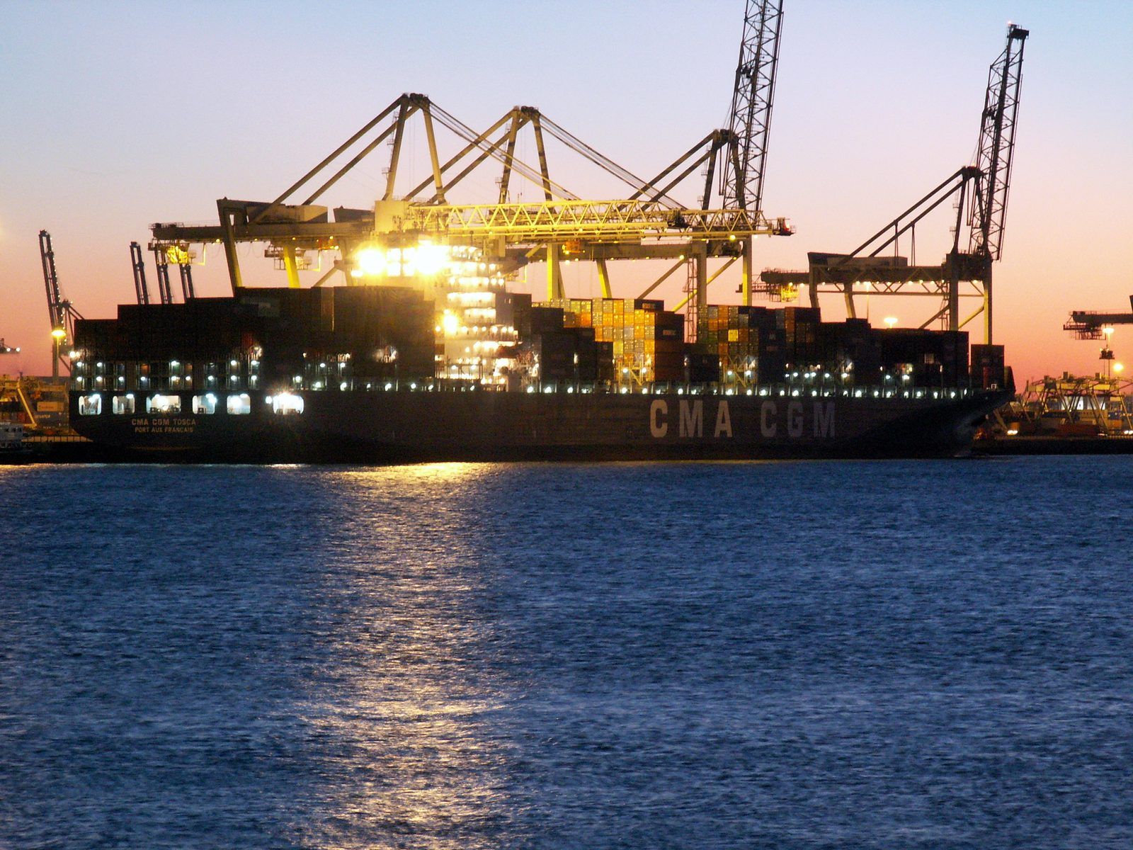 A container ship alongside a terminal at dusk